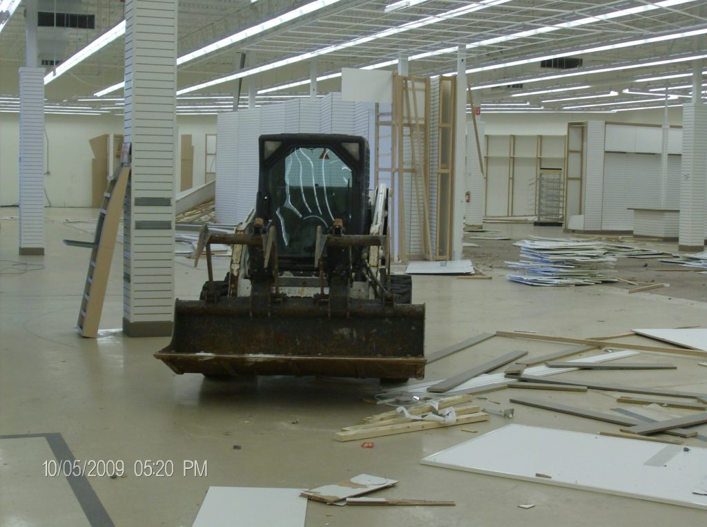 About - Indoors of a building being constructed with a small bobcat vehicle inside